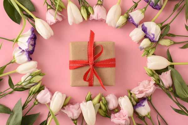 Flatlay of Gift with Bow and Spring Flowers Put in Round